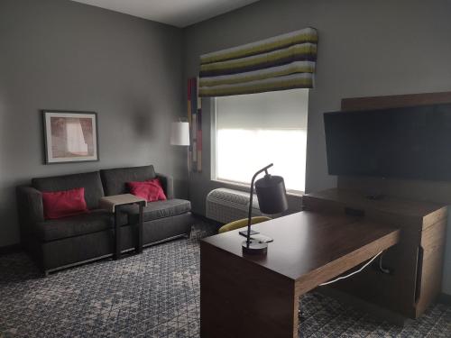 a living room with a couch and a flat screen tv at Hampton Inn & Suites Pittsburgh New Stanton PA in New Stanton