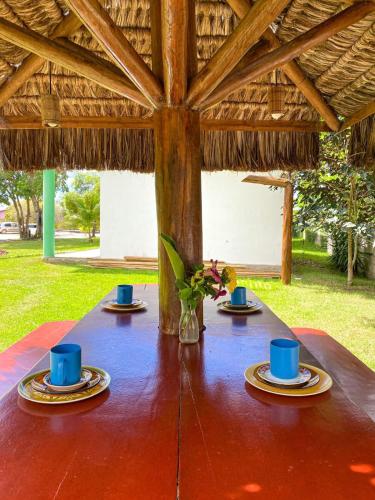 a table with blue cups and plates on top of it at Corumbau Recanto dos Pássaros in Corumbau