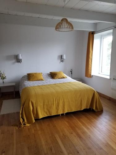 une chambre avec un lit avec une couverture jaune dans l'établissement La maison de Francine, à Plouézec