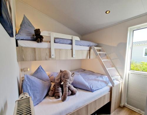 two bunk beds in a tiny house with stuffed animals at Ostseeferienpark Walkyrien - Lotse 11 in Neustadt in Holstein