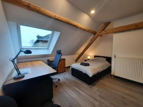 a bedroom with a bed and a desk with a lamp at Chambres privées au calme avec espaces partagés in Metz