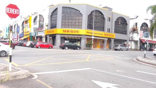 an empty street with cars parked in front of a building at Townhill Guesthouse @ Bandar Teknologi Kajang in Semenyih