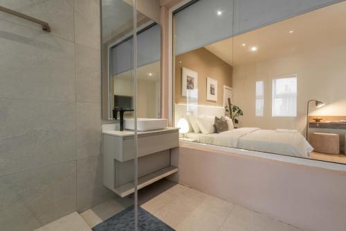 a bathroom with a sink and a bed and a mirror at The Metropolis Lekki in Lekki