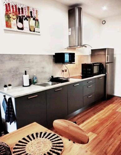 une cuisine avec un évier et un plan de travail dans l'établissement Le CoEuR du ViGnObLe Capacité 16 personnes max Venez partager un moment agréable en famille amis couples jeux Pétanque jacuzzi, à Épernay