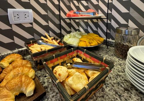 a table with two trays of different types of bread at INGA by DOT Suites in Puerto Iguazú