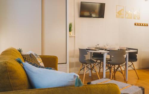 a living room with a couch and a table with chairs at Le Flocon Doré in Cauterets