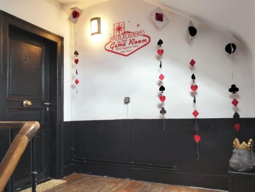 a room with a wall decorated with red and black decorations at Le CoEuR du ViGnObLe Capacité 16 personnes max Venez partager un moment agréable en famille amis couples jeux Pétanque jacuzzi in Épernay