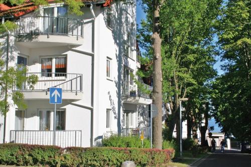 a white building with a blue sign in front of it at Komfortferienwohnung Leuchtturm in Sassnitz