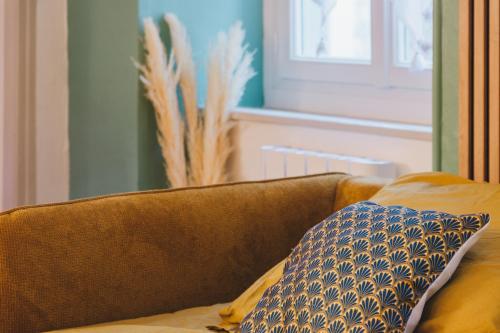 a brown couch with a pillow in a living room at Le Flocon Doré in Cauterets
