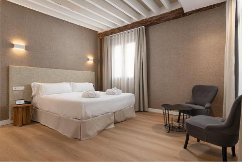 a hotel room with a bed and a chair at Brondo Architect Hotel in Palma de Mallorca