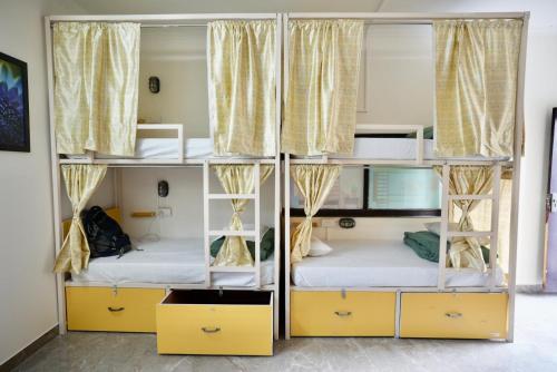two bunk beds in a room with yellow shelves at Heistel Gurugram in Gurgaon