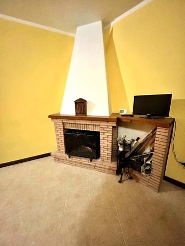 a brick fireplace with a laptop on top of it at All'orologio 2 Camere, Barbecue, Terrazza, Vista in San Donato Val di Comino