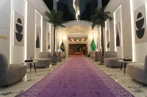 a hallway with palm trees and a purple carpet at فندق سفن دريم in Al Kharj