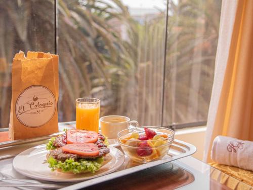 a tray with a plate of food and a glass of orange juice at HOTEL AVENIDA in Tacna