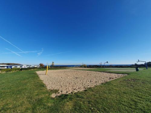 a field with a volley ball hoop in the grass at Campingland Ostsee - Mobilheim 74Strandzauber NEU! in Schashagen