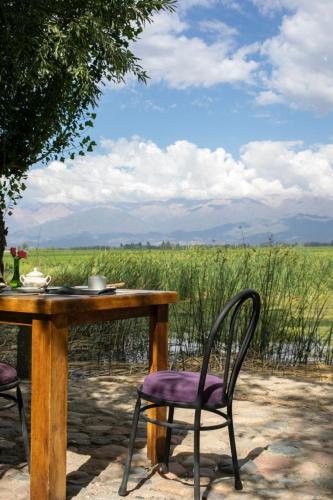 a table with two chairs and a table with a field at Finca La Pichona in Los Árboles
