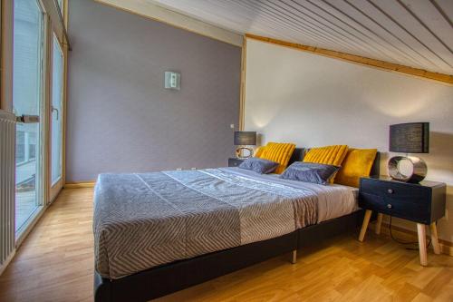 a bedroom with a large bed with yellow pillows at Echapée secrète in Rumilly
