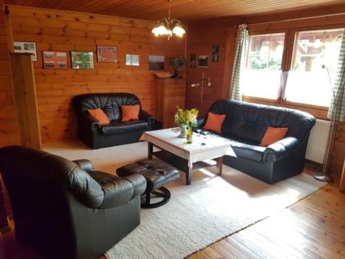 a living room with leather couches and a table at Ferienwohnung Dehnsen in Amelinghausen