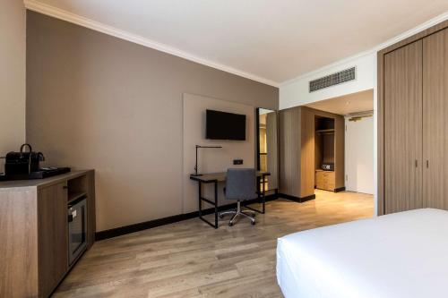 a hotel room with a bed and a desk at NH Luxembourg Airport in Luxembourg