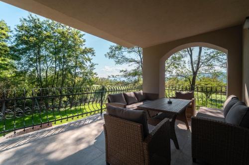 a patio with a table and chairs and a balcony at House Boshanar in Drežnik Grad