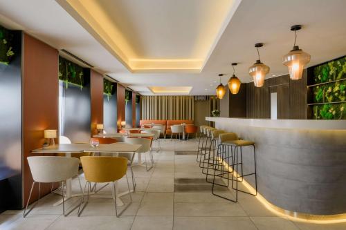 a restaurant with tables and chairs and a bar at NH Collection Madrid Colón in Madrid
