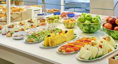a buffet with many different types of food on a table at NH Collection Madrid Colón in Madrid