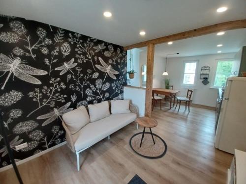 a living room with a couch and a wall mural at Rösslerhof Ferienwohnung Nachtweide in Schlier-Unterankenreute
