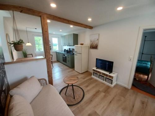 a living room with a couch and a kitchen at Rösslerhof Ferienwohnung Nachtweide in Schlier-Unterankenreute