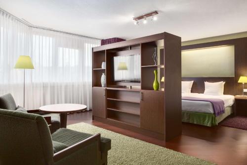 a hotel room with a bed and a tv at NH Maastricht in Maastricht