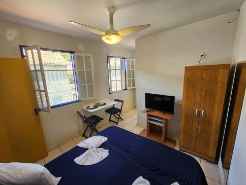 a bedroom with a blue bed and a desk at Pousada Janelas de Ouro Prêto in Ouro Preto