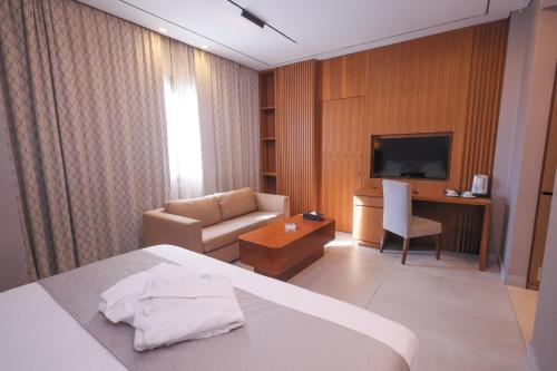 a hotel room with a bed and a couch and a television at Heaven Prestige Hotel in Jounieh