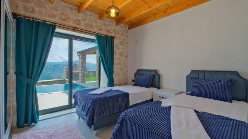 a bedroom with two beds and a large window at Villa TEPE in Arsaköy