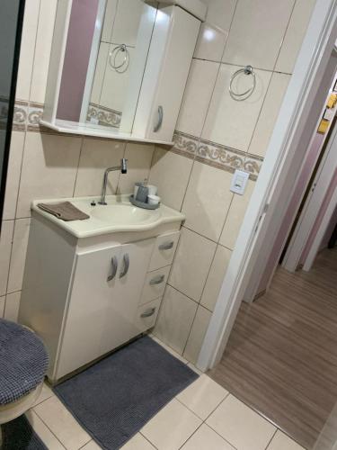 a small bathroom with a sink and a shower at Apartamento Champagne rosé in Garibaldi