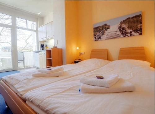 ein großes weißes Bett mit Handtüchern darüber in der Unterkunft Studio Ostseewind Residenz Seeblick in Ostseebad Sellin