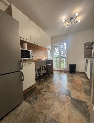 Il comprend une cuisine équipée d'un réfrigérateur et d'une table. dans l'établissement La Belle Escale à Perpignan, à Perpignan