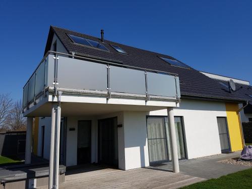 een huis met een glazen balkon bij Villa Aquila Luxus-Maisonette Ferienträume Dachterrasse in Göhren-Lebbin