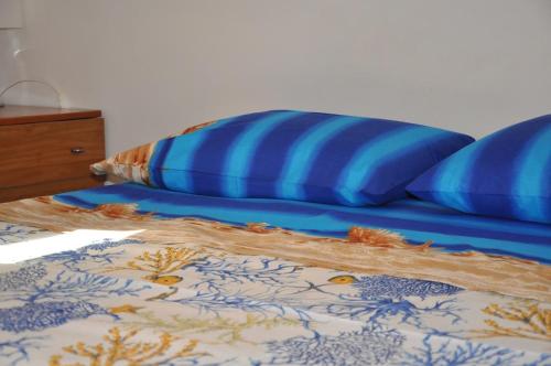 a bed with two blue pillows on top of it at Incatevole sul mare in Belmonte Calabro