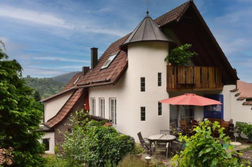 a large white house with a table and an umbrella at Lieselhaus in Busenberg