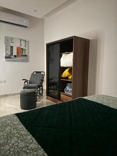 a bedroom with a bed and a chair in a room at شاليه خاص ومميز بأحدث الموصفات in Riyadh