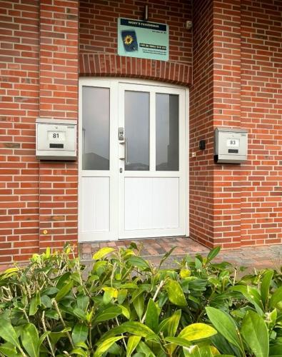a white door on the side of a brick building at Nicky's Ferienhaus in Geeste