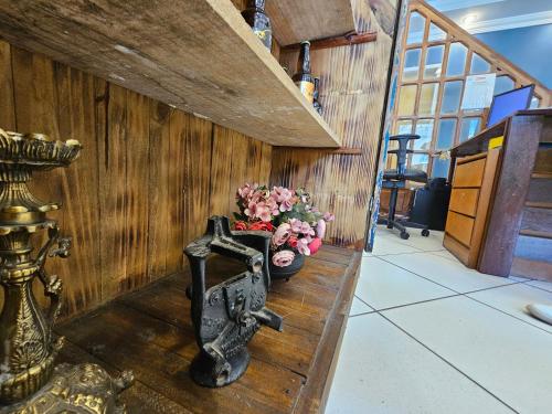 a wooden wall with a cross and flowers on a table at Pousada Janelas de Ouro Prêto in Ouro Preto