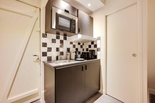 une petite cuisine avec un évier et un micro-ondes dans l'établissement Charming apartment - 1BR- 4P- Arts et métiers, à Paris