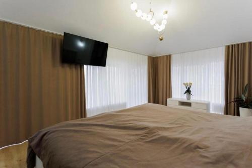 a bedroom with a bed and a flat screen tv at Starvilla in Budeşti