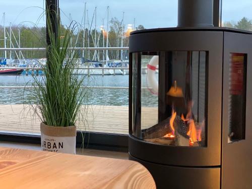 a fireplace sitting next to a table next to a window at Hausboot Träumerei - LP3 in Peenemünde