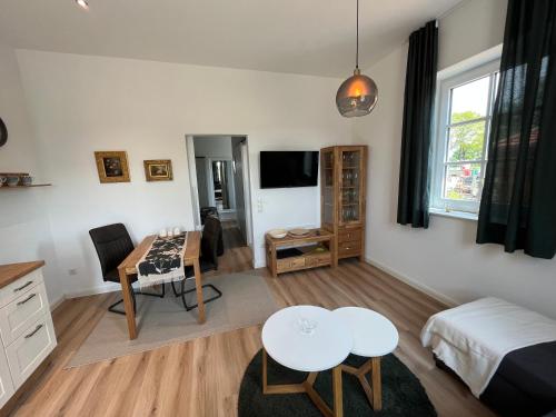a living room with a table and a dining room at Martje in Lastrup