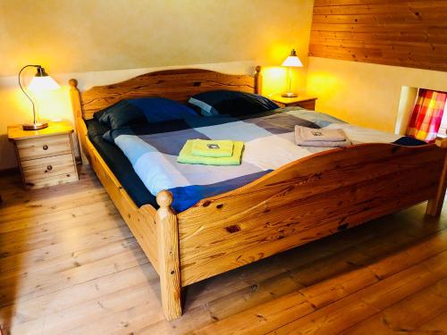 a large wooden bed in a bedroom with two lamps at Tante Kamps Hus - Uriges Häuschen mit Garten und Geschichte in Bönstrup