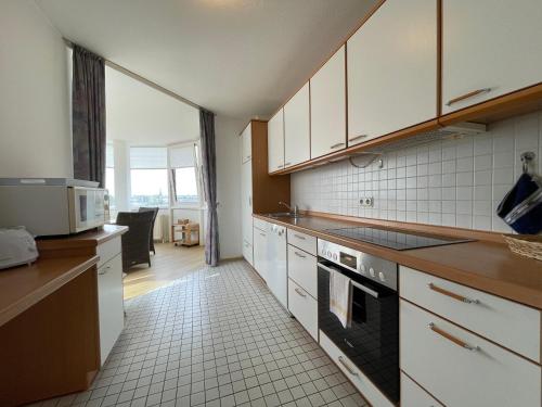 a kitchen with white cabinets and a stove top oven at Apartment 22 in Wilhelmshaven