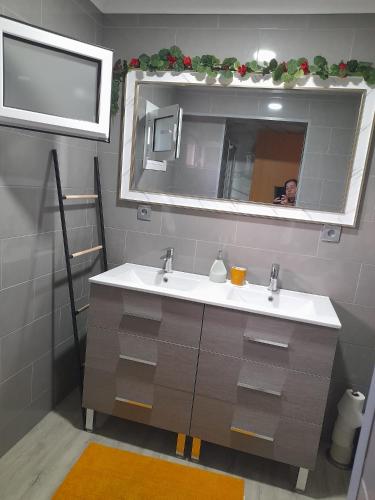 a man taking a picture of a bathroom with a sink at Paraíso da Foz do Sabor in Torre de Moncorvo