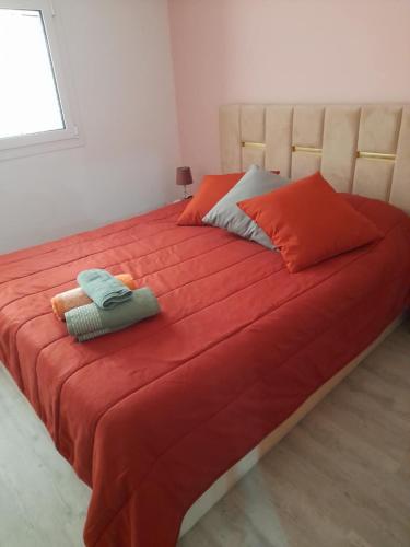 a large bed with red sheets and pillows on it at Paraíso da Foz do Sabor in Torre de Moncorvo