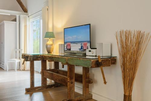 a room with a desk with a computer on it at Klüterkammer, Ferienhaus auf Gutshof mit Kamin in Langballig